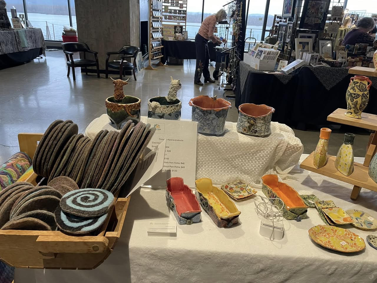 Workshop table with handmade ceramics, woven goods, and craft supplies