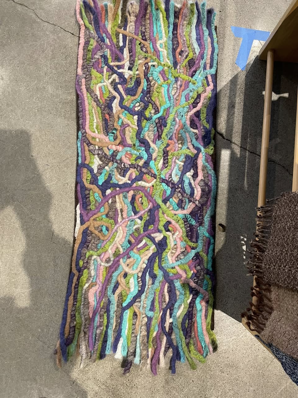 Colorful woven textile art piece with abstract pattern