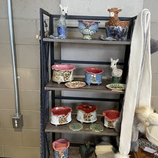 Handmade ceramic animal figurines and planters on shelves