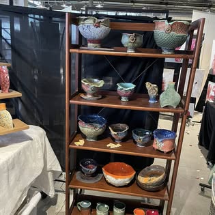 Shelf of handmade ceramic bowls in colorful glazes